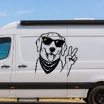 Sticker chien souriant avec lunettes et foulard faisant un signe de paix