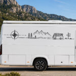 Sticker linéaire avec montagnes, sapins, van vintage, rose des vents et panneau directionnel