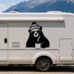 Sticker ours hipster avec bonnet, lunettes et tasse fumante sur un camping-car