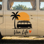 Sticker van vintage avec palmier, soleil couchant, oiseaux et texte Van Life sur porte de véhicule